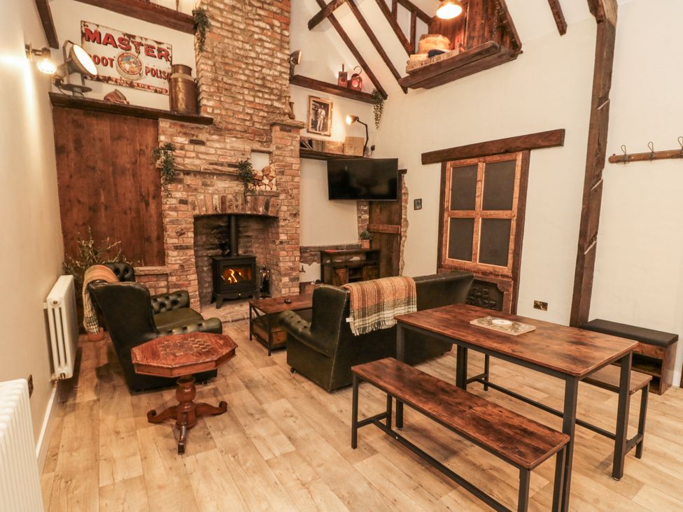 A living room with a fireplace and wooden furniture at Dotty's Den in Bridlington