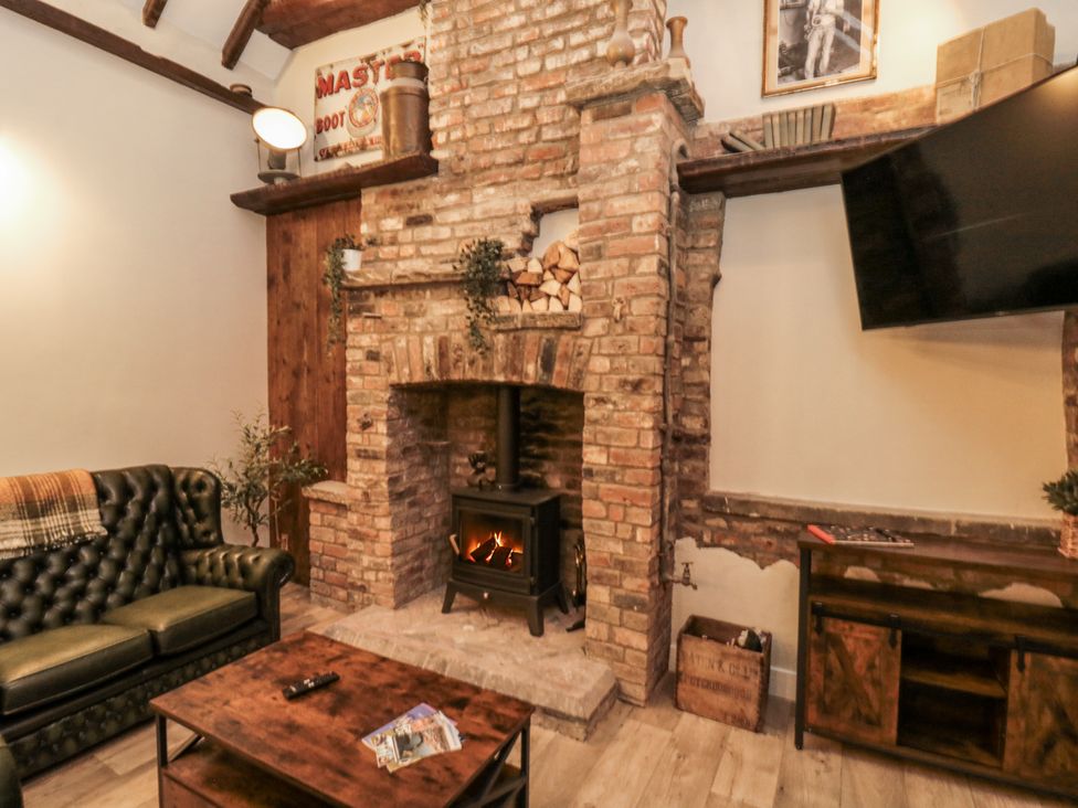 A living room with a fireplace and sofa at Dotty's Den in Bridlington