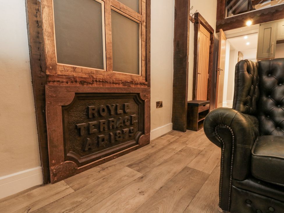 A living room featuring a door and a leather sofa at Dotty's Den in Bridlington
