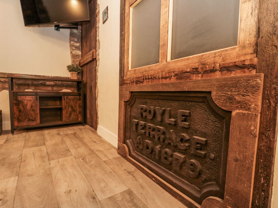 A living room with a television and wooden table at Dotty's Den in Bridlington