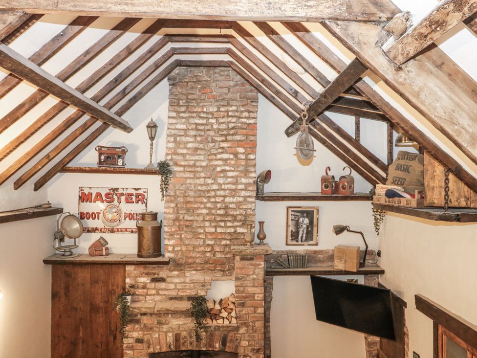 A snug with a brick fireplace and wooden beams at Dotty's Den in Bridlington
