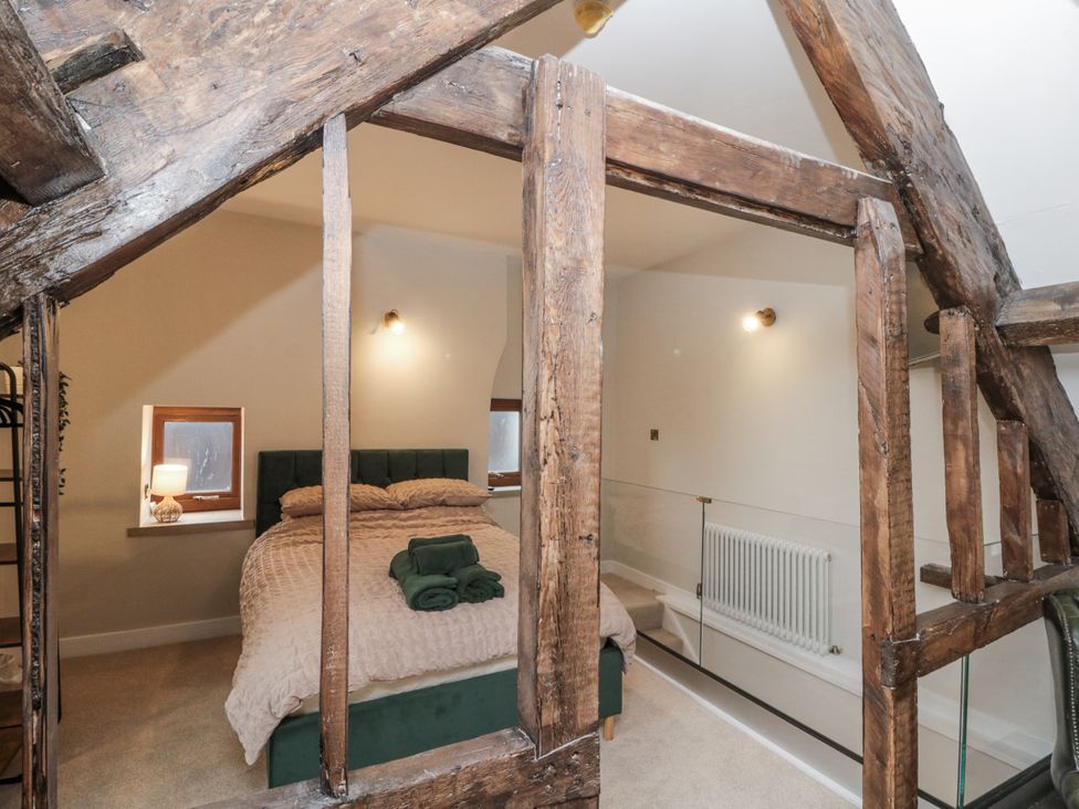 A bedroom with a bed and windows at Dotty's Den in Bridlington