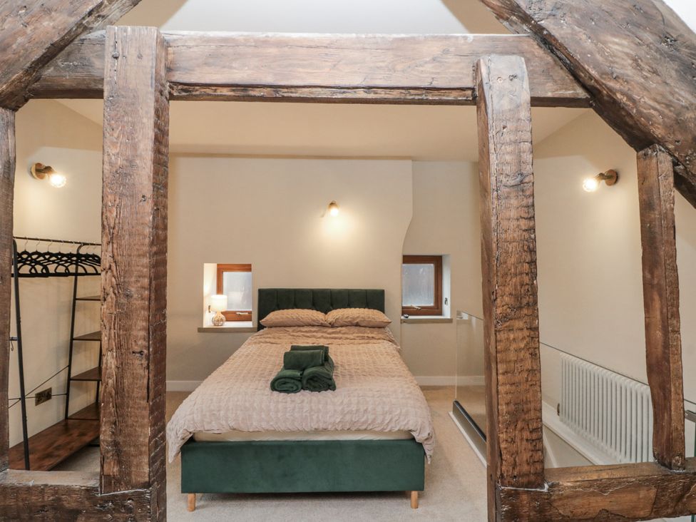 A bedroom with a bed and shelves at Dotty's Den in Bridlington