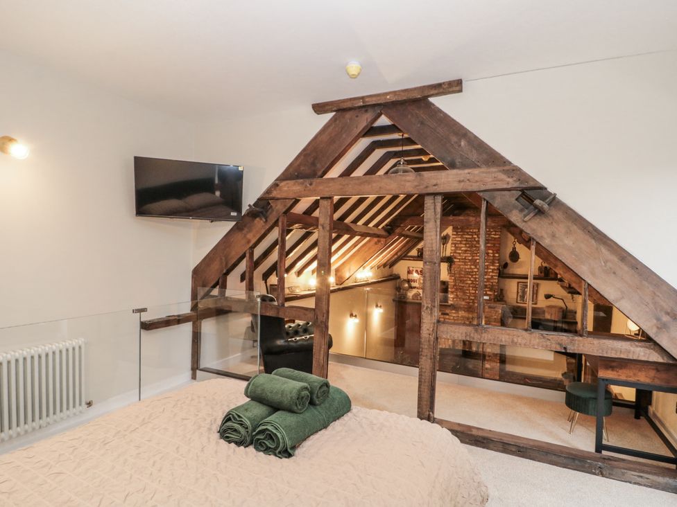 A loft with a bed and television at Dotty's Den in Bridlington