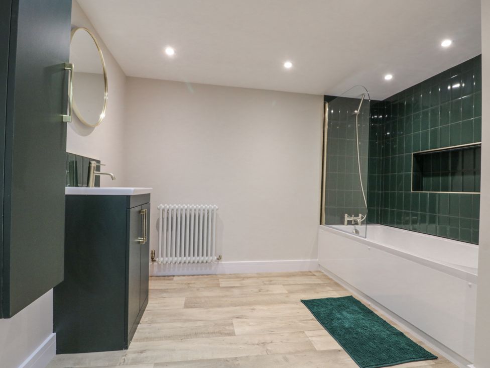 A bathroom with a bathtub and washbasin at Dotty's Den Bridlington