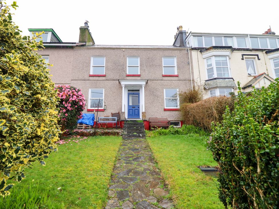 A house with a blue door and a garden at Garth Celyn in Porthmadog