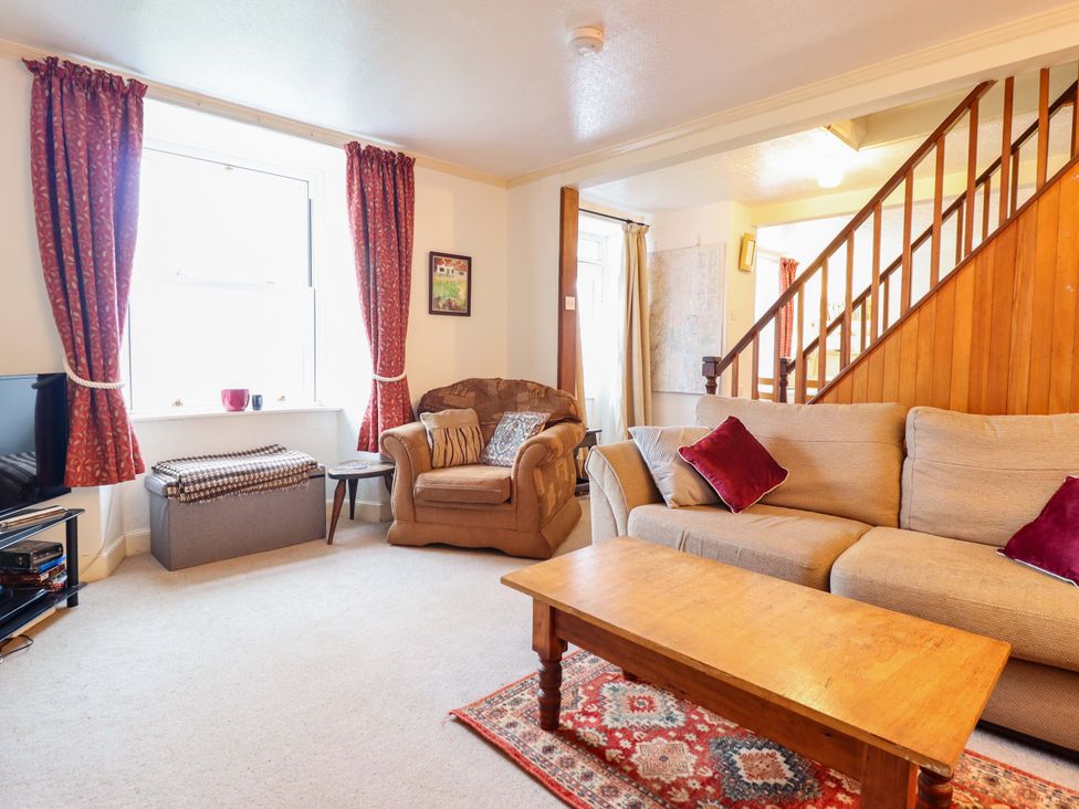 A living room with a sofa, armchair, and coffee table at Garth Celyn in Porthmadog