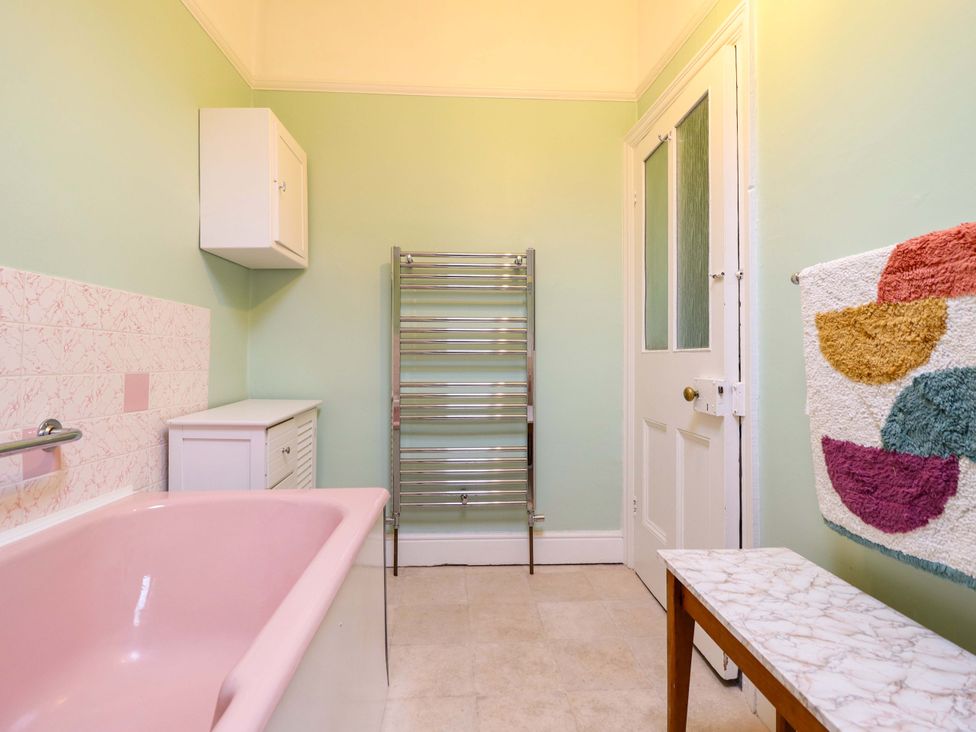 A bathroom with a bathtub and shelves at Garth Celyn in Porthmadog