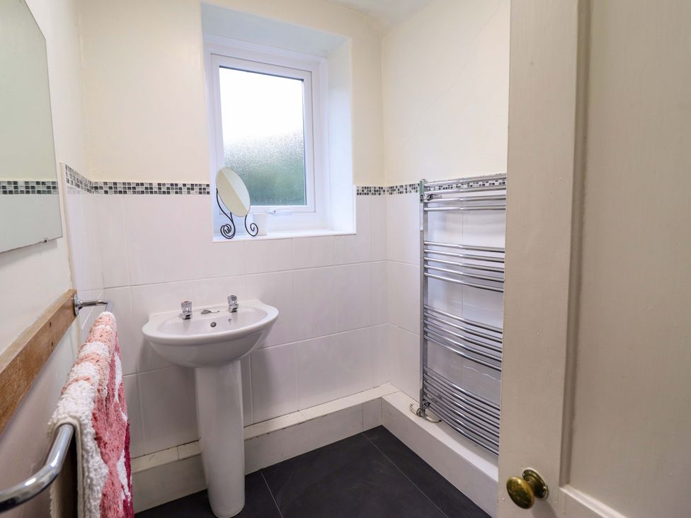 A bathroom with a sink and a heated towel rail at Garth Celyn in Porthmadog