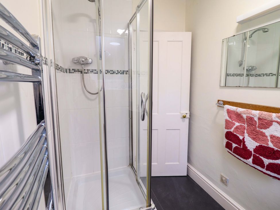 A bathroom with a shower and towel rack at Garth Celyn in Porthmadog