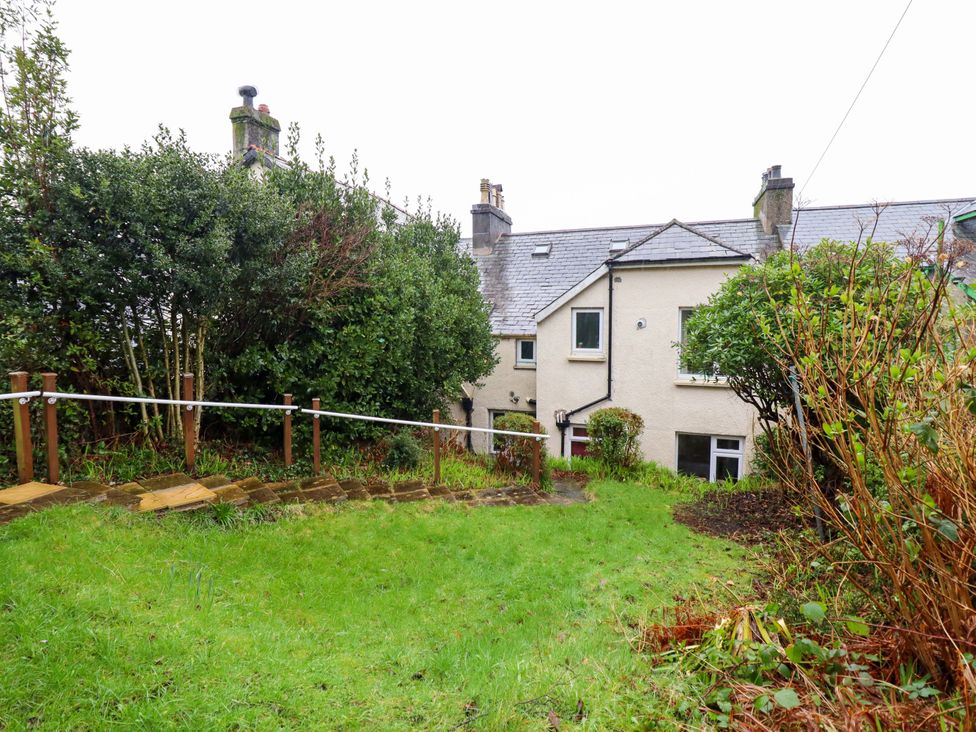 A garden with a house in the background at Garth Celyn in Porthmadog