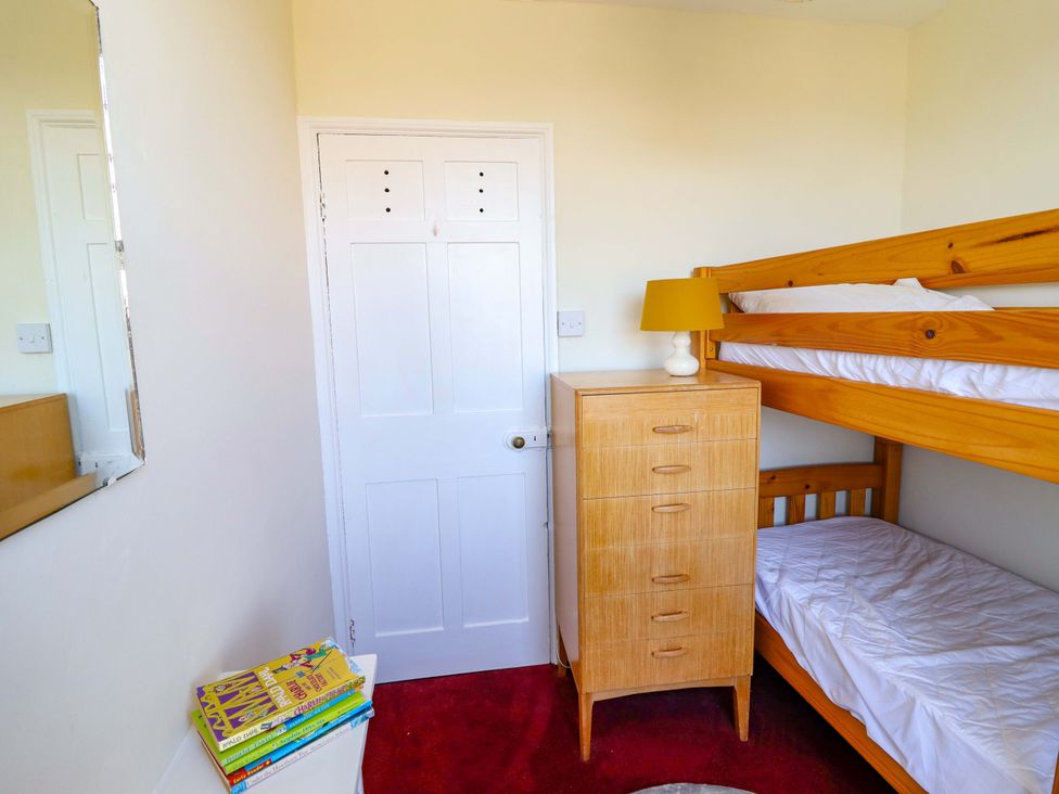 A bedroom with a bunk bed and dresser at Garth Celyn in Porthmadog
