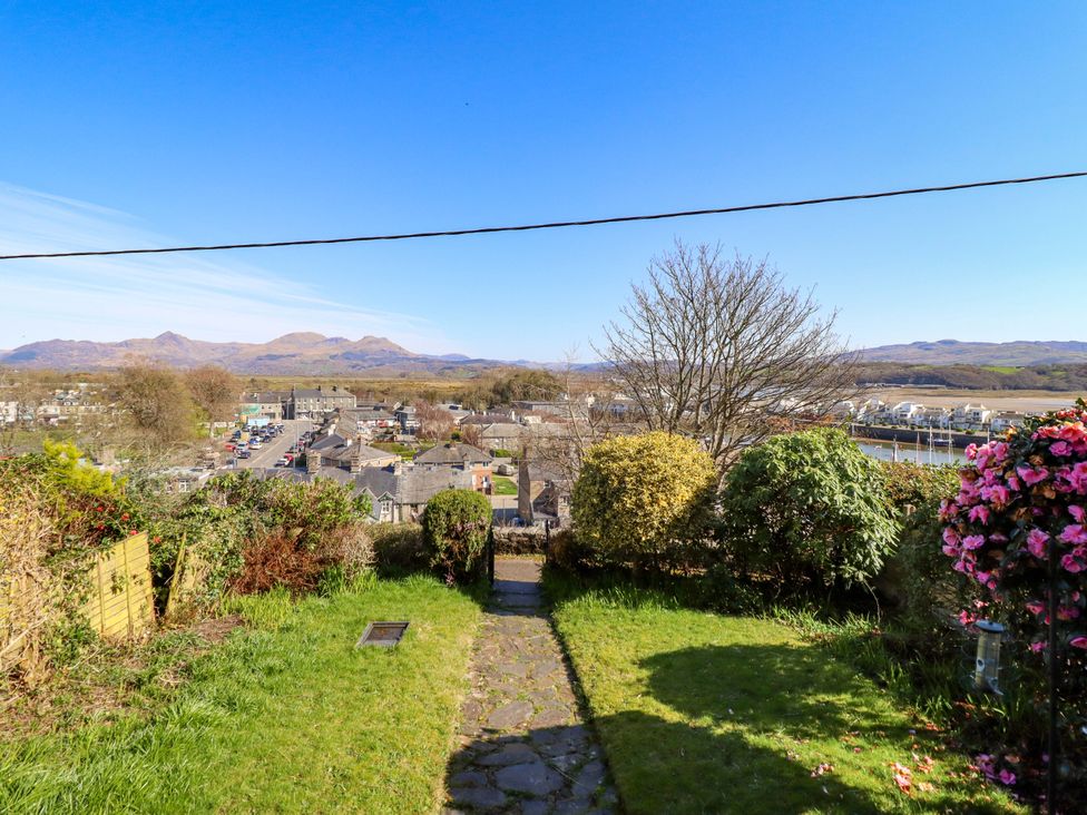 A garden with a pathway and view of the mountains at Garth Celyn in Porthmadog