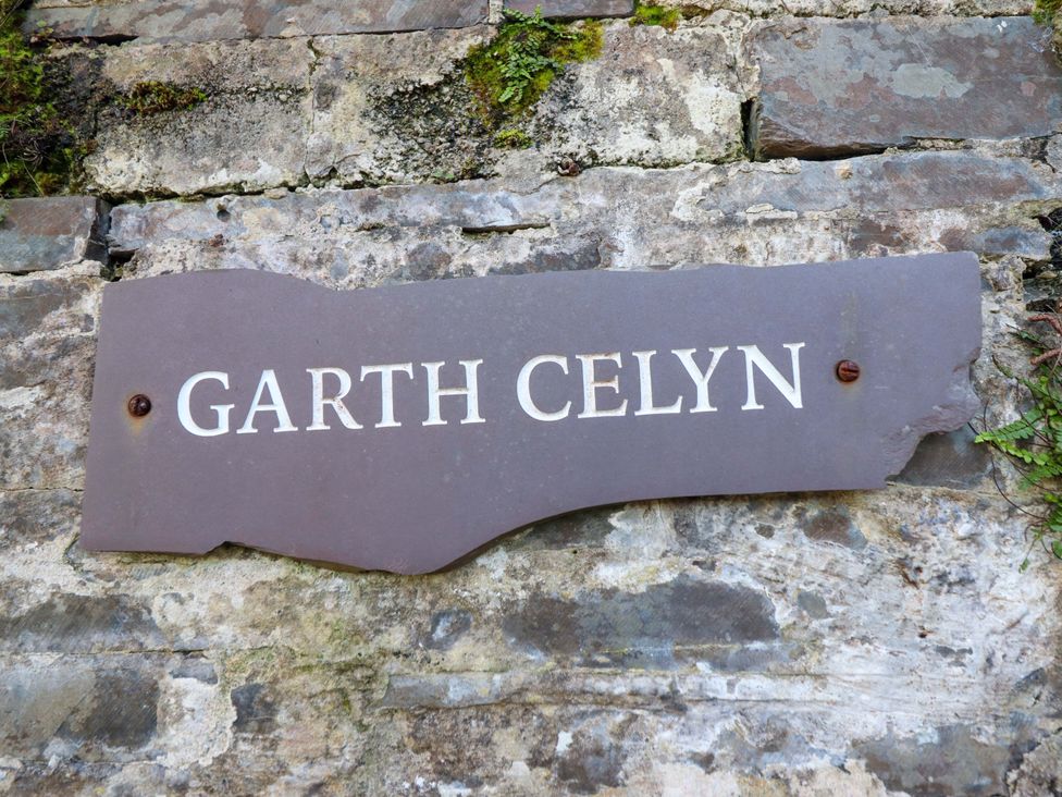 A sign displaying Garth Celyn on a stone wall in Porthmadog