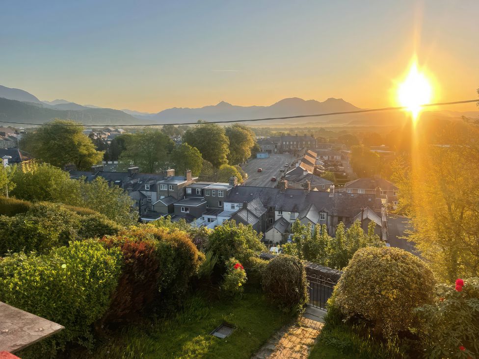 A view of houses and mountains at sunset at Garth Celyn in Porthmadog