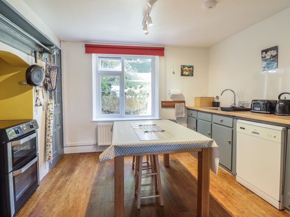 A kitchen with a table and appliances at Garth Celyn in Porthmadog