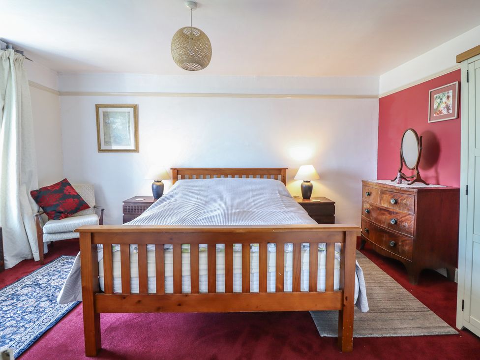 A bedroom with a bed and nightstand at Garth Celyn in Porthmadog