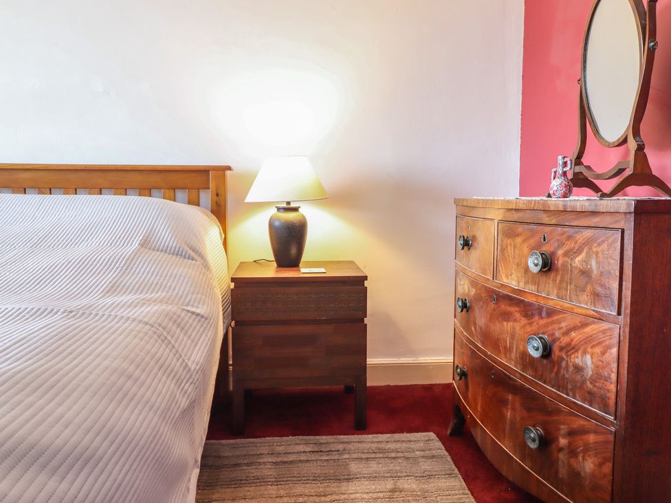 A bedroom with a bed and nightstand at Garth Celyn in Porthmadog