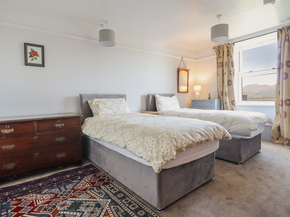 A bedroom with twin beds and a chest of drawers at Garth Celyn in Porthmadog