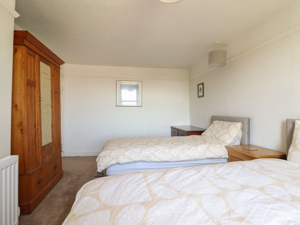 A bedroom with two beds and wardrobe at Garth Celyn in Porthmadog