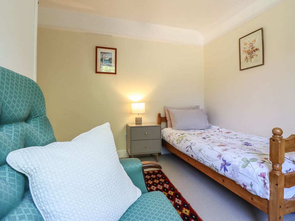 A bedroom with a bed and chair at Garth Celyn Porthmadog