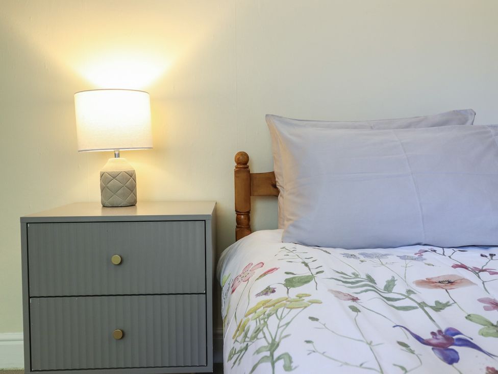 A bedroom with a bed and nightstand at Garth Celyn in Porthmadog