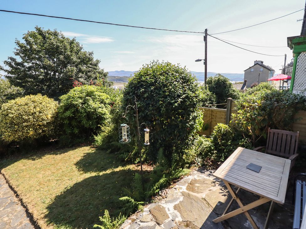 A garden with bushes and a table at Garth Celyn in Porthmadog