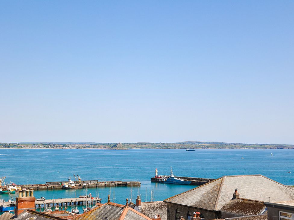 A view of a harbor with boats and hills at Kittiwake in Newlyn