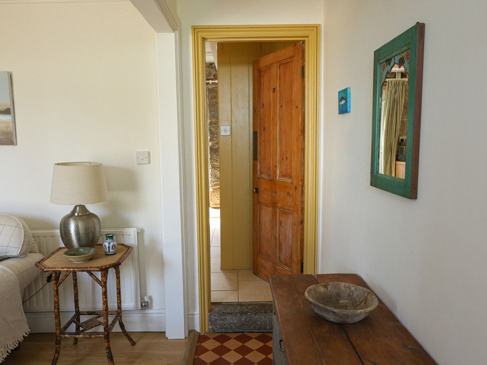 A hallway with a door and table at Kittiwake in Newlyn