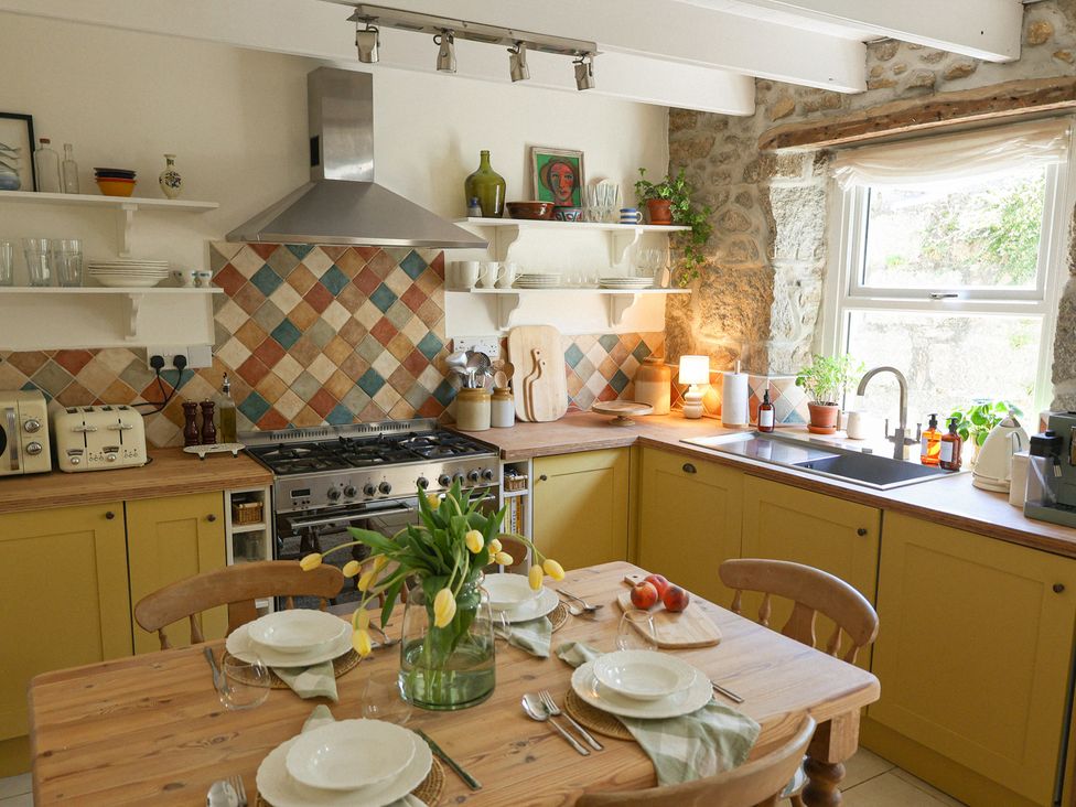A kitchen with a table and chairs at Kittiwake in Newlyn