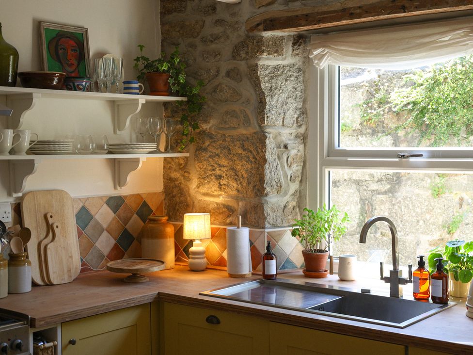 A kitchen with a sink and plants at Kittiwake in Newlyn