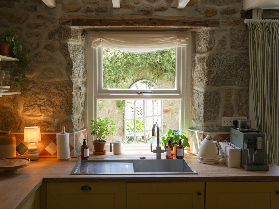 A kitchen with a sink and window at Kittiwake in Newlyn