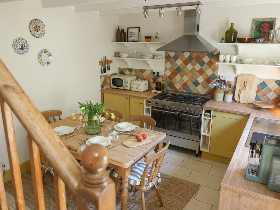 A kitchen with a dining table and stove at Kittiwake in Newlyn