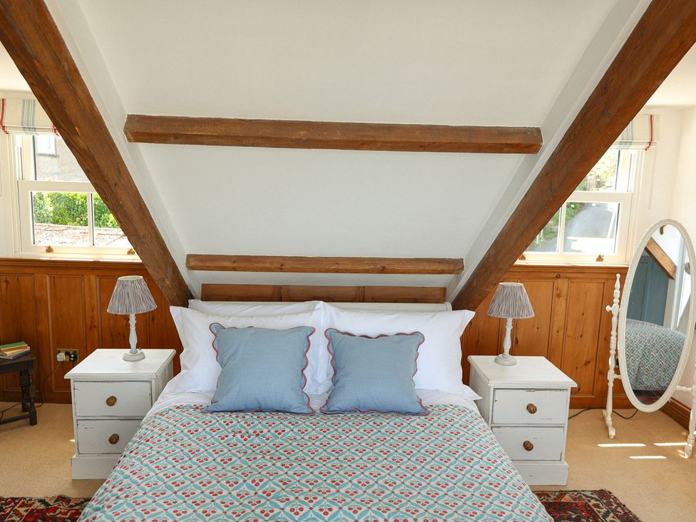 A bedroom with a bed and a mirror at Kittiwake in Newlyn