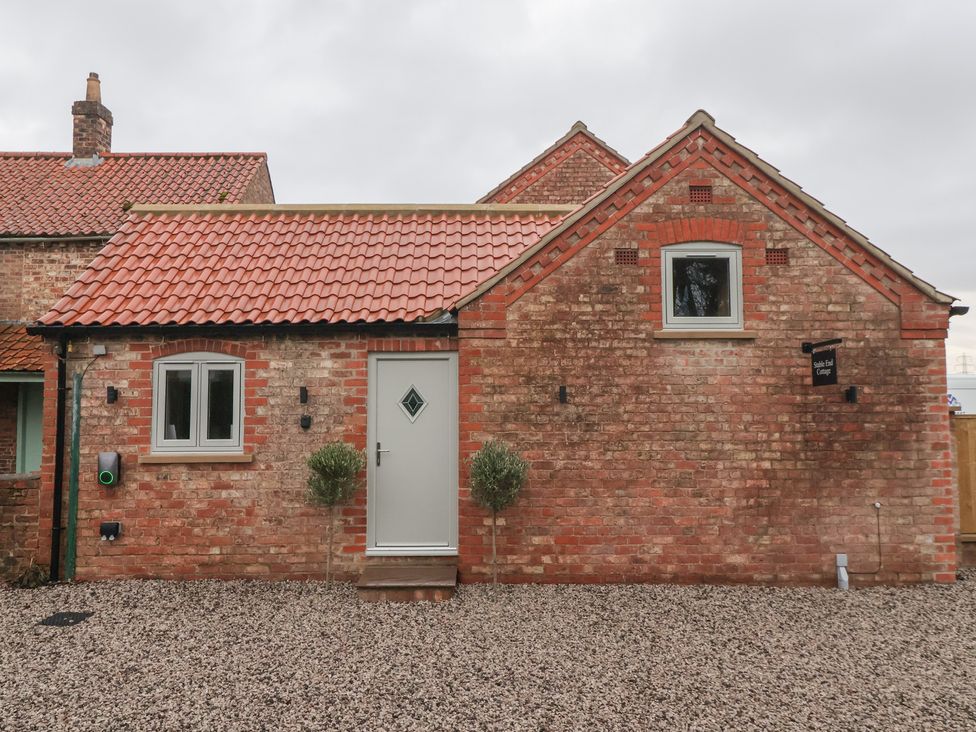 A front view of a cottage with a gravel area at Stable End Cottage in York