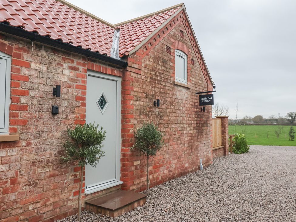 An exterior view of Stable End Cottage in York with brick walls and a gravel path