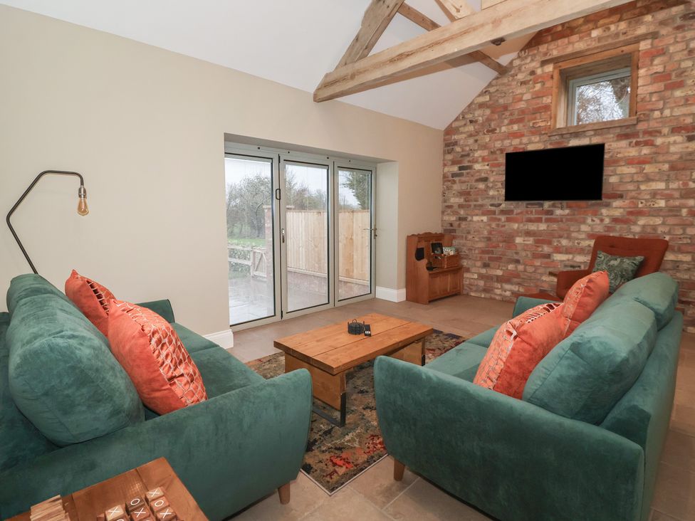 A living room with sofas and a coffee table at Stable End Cottage York