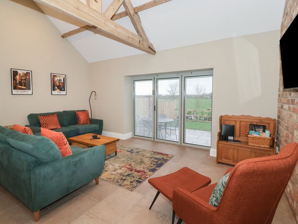 A living room with a sofa and coffee table at Stable End Cottage in York