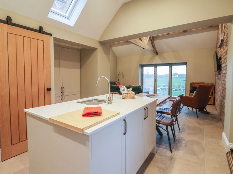 A kitchen with an island and dining area at Stable End Cottage York