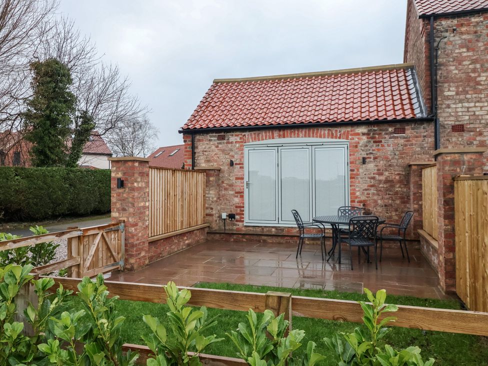An outdoor patio with a table and chairs at Stable End Cottage York