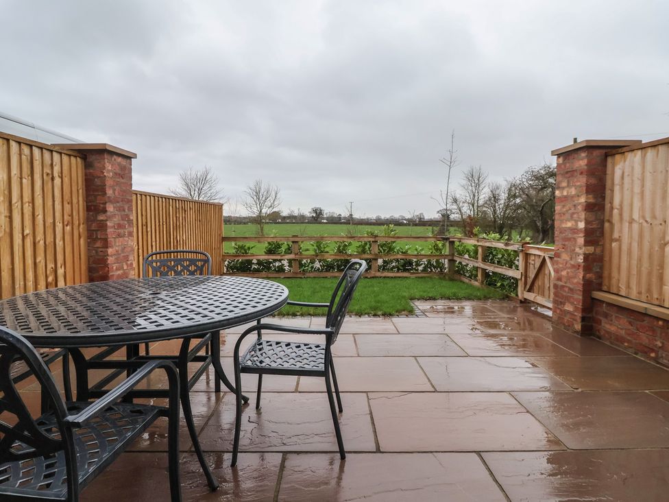 A patio with a table and chairs at Stable End Cottage York