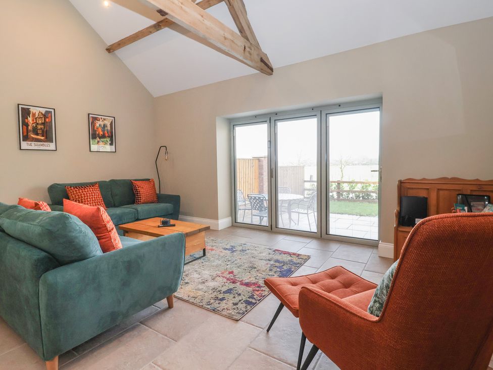 A living room with a sofa and coffee table at Stable End Cottage near Cuckoo Nest Farm