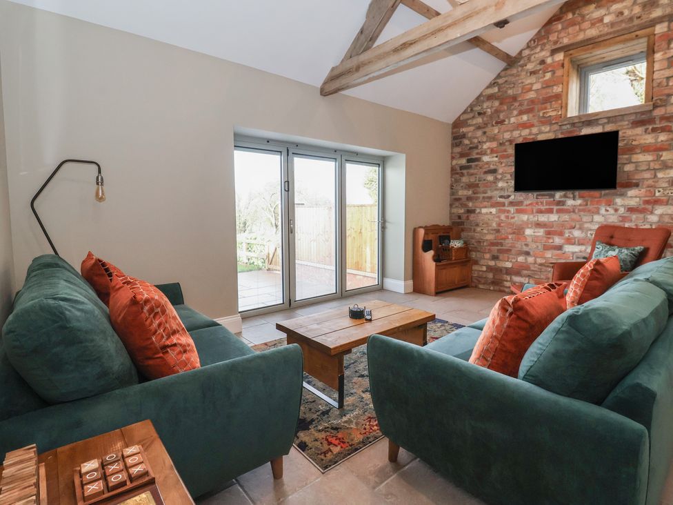 A living room with sofas and a coffee table at Stable End Cottage near Cuckoo Nest Farm