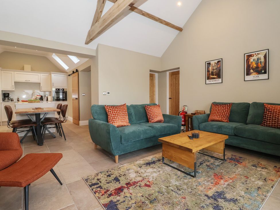 A living room with sofa and dining area at Stable End Cottage Cuckoo Nest Farm near Wilberfoss