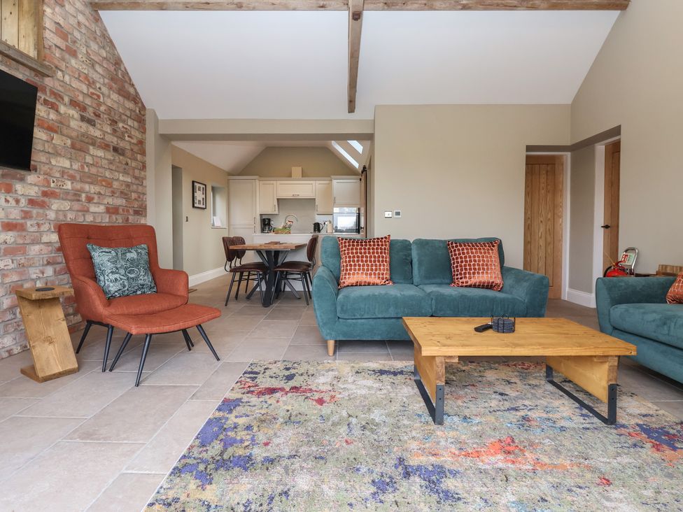 A living room with seating and a dining area at Stable End Cottage near Cuckoo Nest Farm