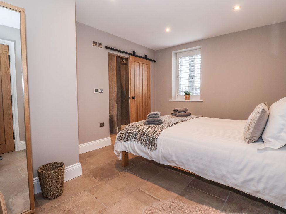 A bedroom with a bed and towels at Stable End Cottage Cuckoo Nest Farm near Wilberfoss