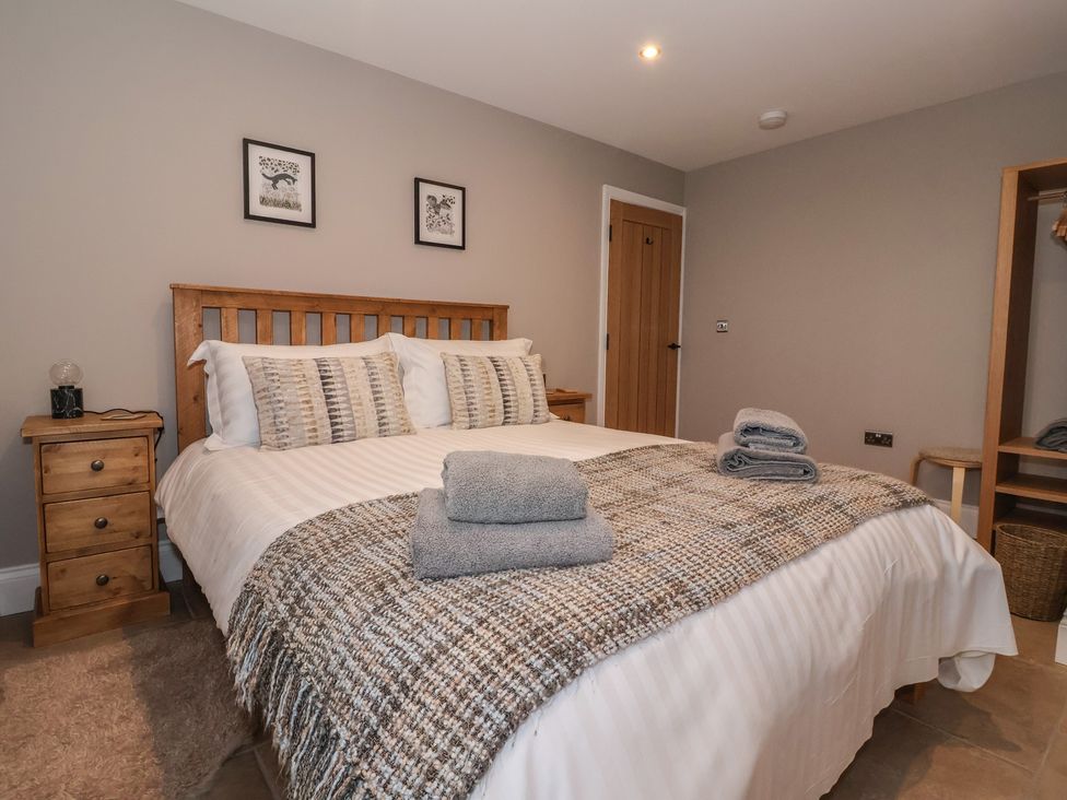 A bedroom with a bed and bedside table at Stable End Cottage near Cuckoo Nest Farm