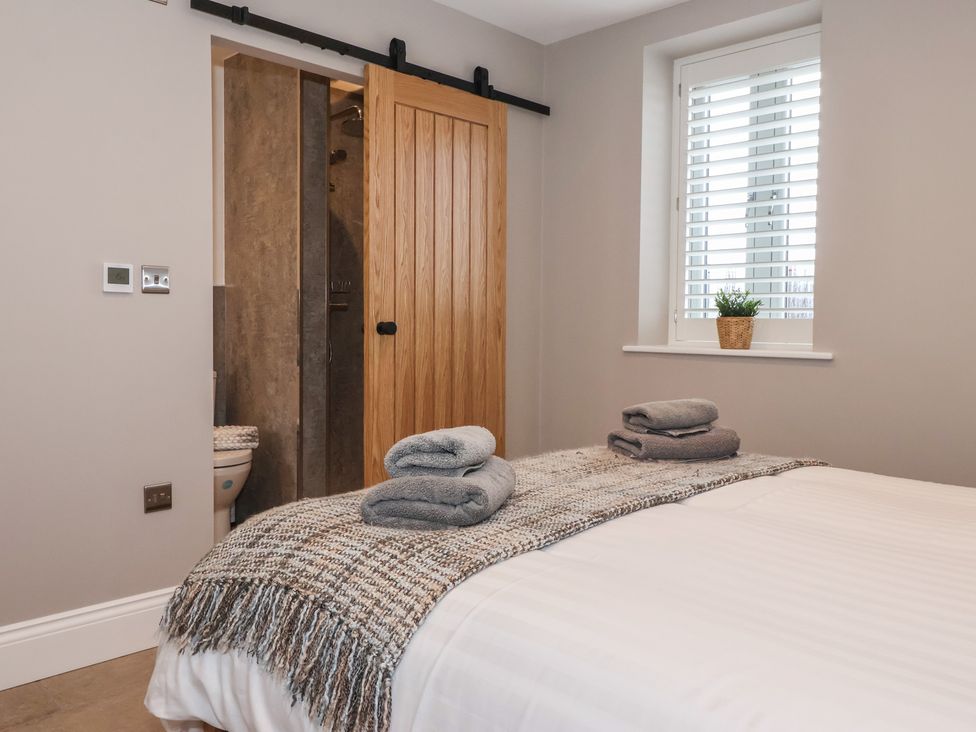 A bedroom with a bed and towels at Stable End Cottage Cuckoo Nest Farm near Wilberfoss