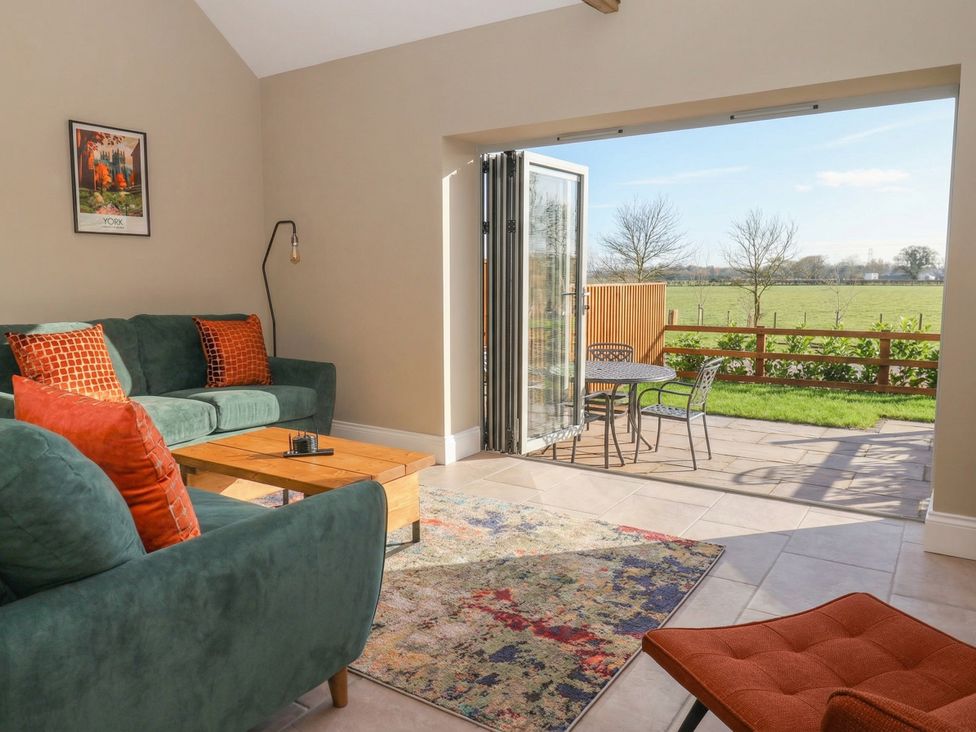 A living room with a sofa and coffee table at Stable End Cottage near Cuckoo Nest Farm