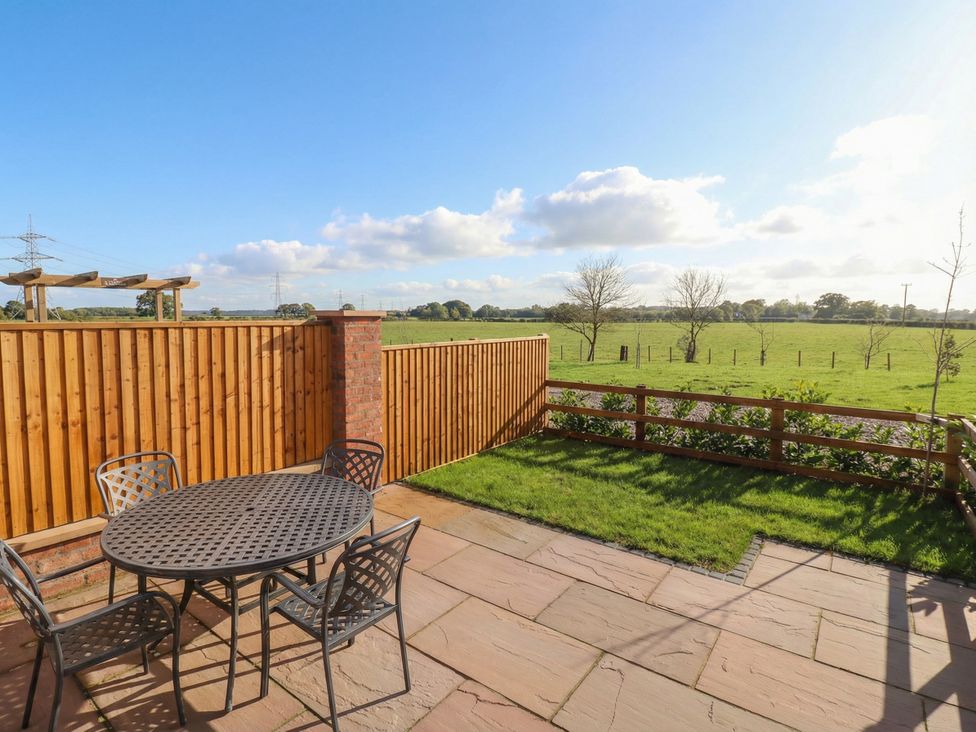 An outdoor patio with a table and chairs at Stable End Cottage near Cuckoo Nest Farm